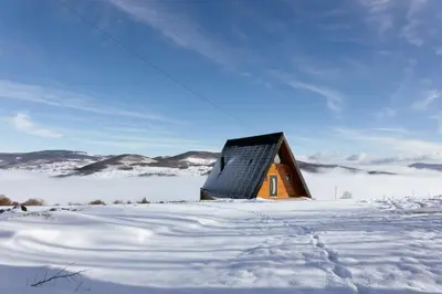 a wooden house in the snow with snow covered ground at Vikendica miRAJ Manjaca in Gornje Ratkovo