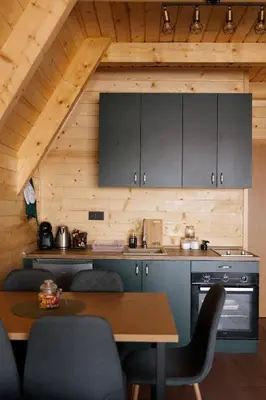a kitchen with a table and a wooden ceiling at Vikendica miRAJ Manjaca in Gornje Ratkovo