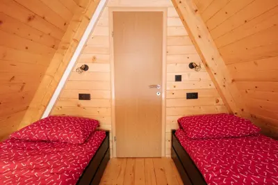 two beds in a room with wooden walls at Vikendica miRAJ Manjaca in Gornje Ratkovo