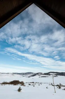 a view through a window of a snow covered field at Vikendica miRAJ Manjaca in Gornje Ratkovo