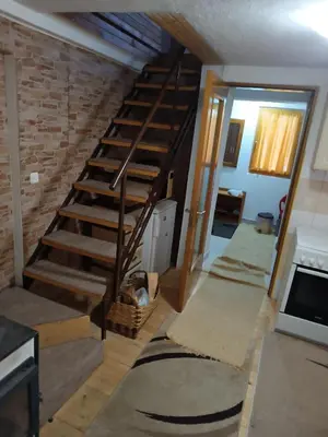 a living room with a spiral staircase with rugs at Relaks dream in Vlasic