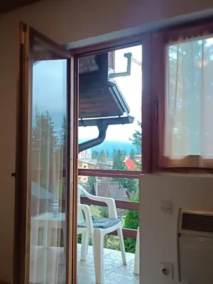 a kitchen with a balcony with a stove and a chair at Relaks dream in Vlasic