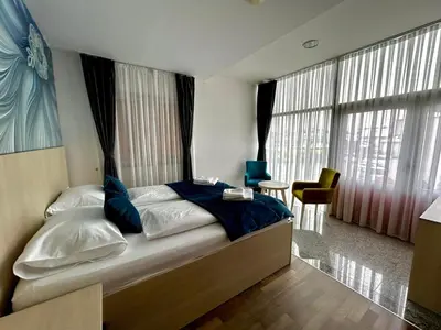 a bedroom with a large bed with blue pillows at Prenoćište Euro-Jet Ćoralići in Ćoralići