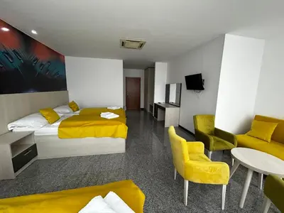a hotel room with two beds and a table and chairs at Prenoćište Euro-Jet Ćoralići in Ćoralići