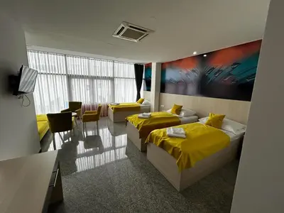 a hotel room with two beds and a table and chairs at Prenoćište Euro-Jet Ćoralići in Ćoralići