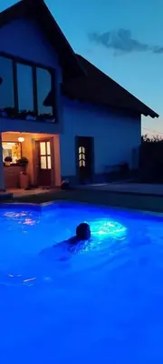 a swimming pool with blue lights in front of a house at Apartman HADŽILUK in Bugojno