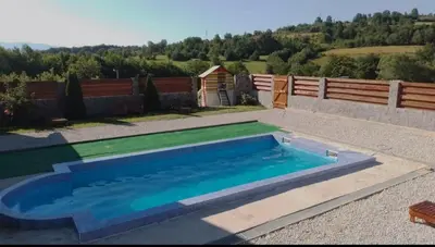 a swimming pool in a yard with a fence at Apartman HADŽILUK in Bugojno