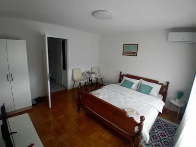 a bedroom with a bed with white sheets and blue pillows at Studio Bulevar in Banja Luka