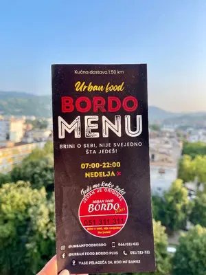 a man hand holding a bottle of bordo menu at Studio Bulevar in Banja Luka
