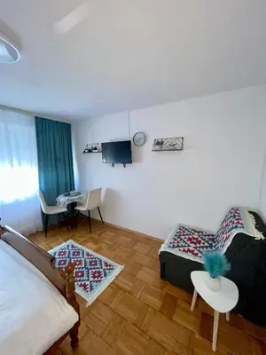 a living room with a bed and a table at Studio Bulevar in Banja Luka