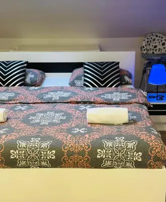 a bed with a blanket and pillows on it at Petra Luxury in Livno
