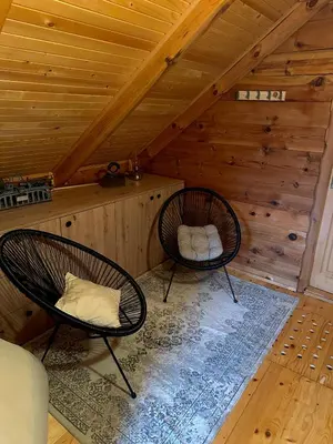 two chairs in a room with a attic at Cozy Wooden Cottage in Banja Luka