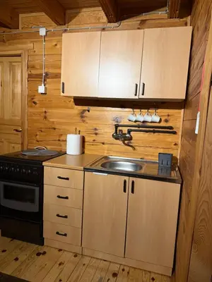 a kitchen with a sink and a stove at Cozy Wooden Cottage in Banja Luka
