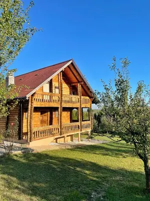 a log cabin with a porch and a yard at Cozy Wooden Cottage in Banja Luka