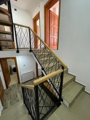 a spiral staircase with a red door in a house at Villa Gabi Vlašić in Travnik