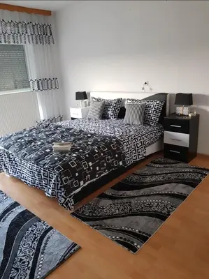 a bedroom with a bed with a black and white comforter at Ferienwohnung Sabina in Bosanska Krupa