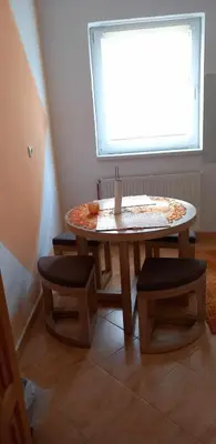 a table and two stools in a room with a window at Ferienwohnung Sabina in Bosanska Krupa