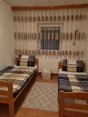two beds sitting in a room with a window at Ferienwohnung Sabina in Bosanska Krupa