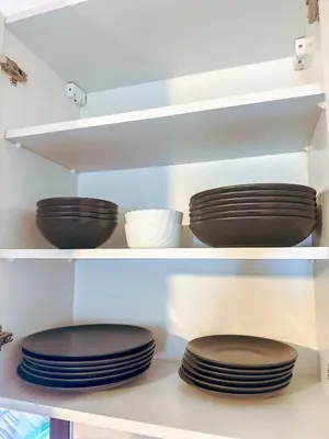 two stacks of plates on shelves in a kitchen at Stan na dan Relax in Bosanska Dubica