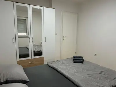 a bedroom with a bed and a large mirror at Apartman Moskva in Teslić