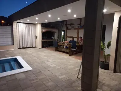 a patio with a pool and a man sitting at a table at Villa Aida in Bihać