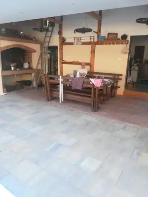 a woman sitting at a wooden table in a room at Villa Aida in Bihać