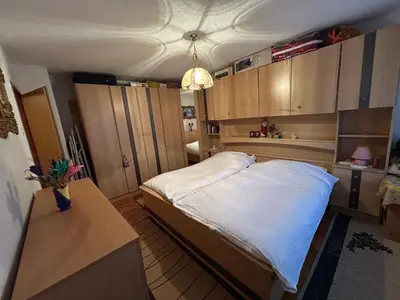 a small bedroom with a bed and a table at Apartman Kuna in Kupres