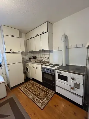 a kitchen with white cabinets and a stove top oven at Apartman Kuna in Kupres