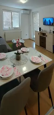 a living room with a table with plates on it at Apartman Rubin20 in Doboj