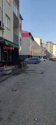 an empty street in a city with cars and buildings at Apartman Rubin20 in Doboj