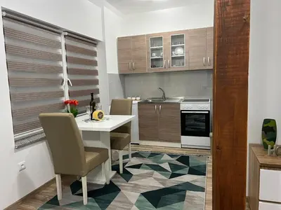 a kitchen with a table and chairs in a kitchen at Apartman Mrša in Livno