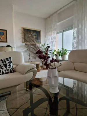 a living room with two white couches and a table at Apartman Pasha in Bihać