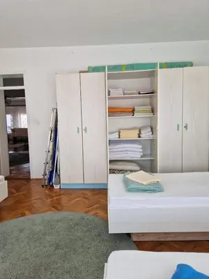 a bedroom with white cabinets and a white bed at Apartman Pasha in Bihać