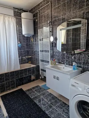 a bathroom with a sink and a washing machine at Apartman Pasha in Bihać