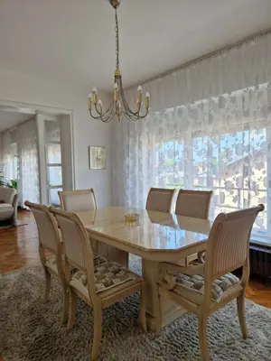 a dining room table with chairs and a chandelier at Apartman Pasha in Bihać