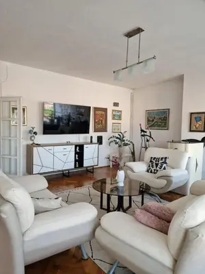 a living room with white furniture and a flat screen tv at Apartman Pasha in Bihać