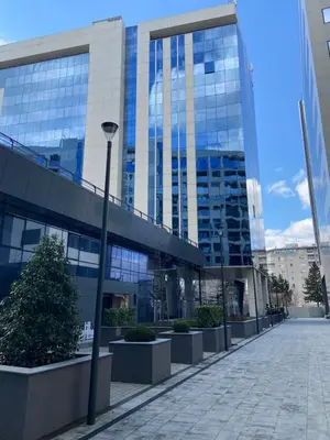 a tall glass building with a street light in front of it at Metropolis Apartman in Banja Luka
