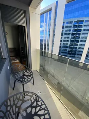 a chair on a balcony with a view of a building at Metropolis Apartman in Banja Luka