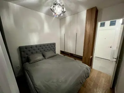 a bedroom with a bed and a chandelier at Metropolis Apartman in Banja Luka