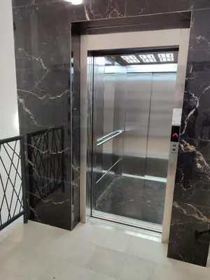 an elevator door in a building with black marble at River Oasis in Banja Luka