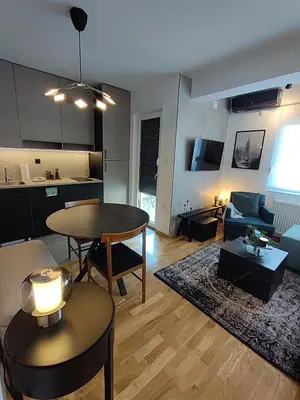 a living room with a table and a kitchen at River Oasis in Banja Luka