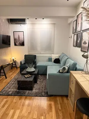 a living room with a blue couch and a table at River Oasis in Banja Luka