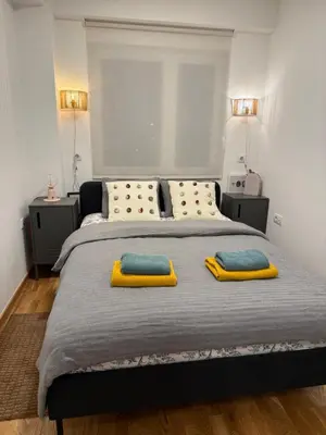 a bedroom with a large bed with two yellow pillows at River Oasis in Banja Luka