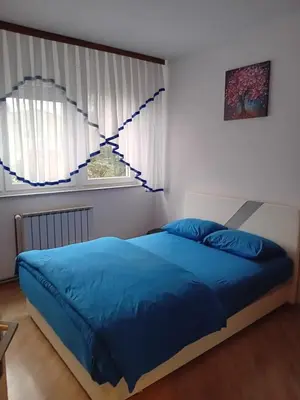 a bedroom with a blue bed and a window at Stan na dan Miki -M Teslic in Teslić