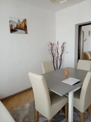 a dining room with a table and white chairs at Stan na dan Miki -M Teslic in Teslić