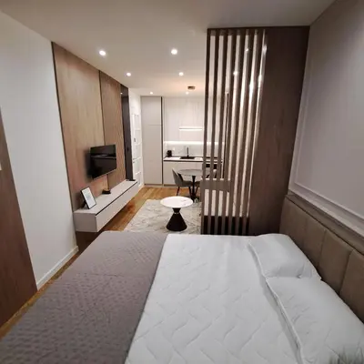 a bedroom with a large bed and a television at Apartman LUAN5 centar in Banja Luka