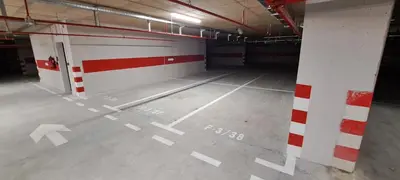 an empty parking garage with white and red markings on the floor at Apartman LUAN5 centar in Banja Luka