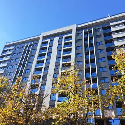 a tall building with trees in front of it at Apartman LUAN5 centar in Banja Luka