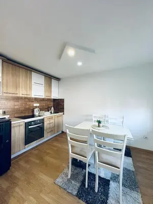 a kitchen with a white table and two white chairs at Apartman 007 in Jajce