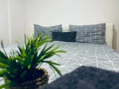 a bedroom with a bed with two potted plants at Apartman 007 in Jajce